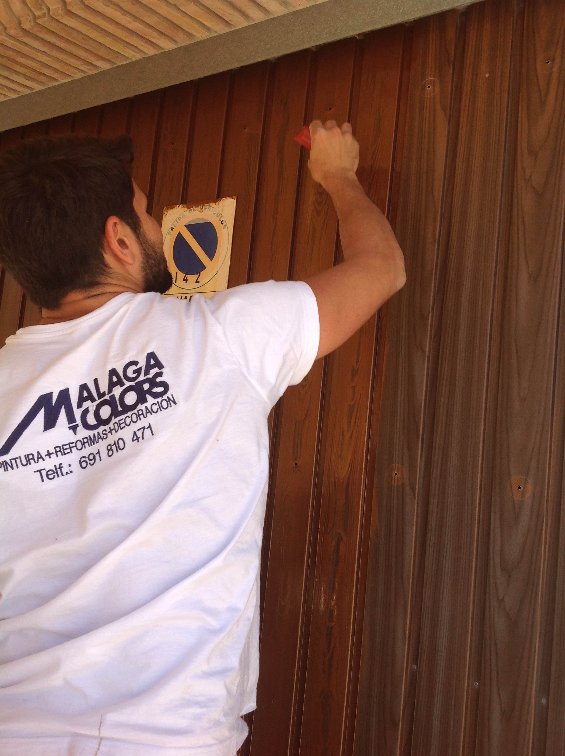 Imitaciones en madera al restaurar una puerta metálica, Málaga Colors